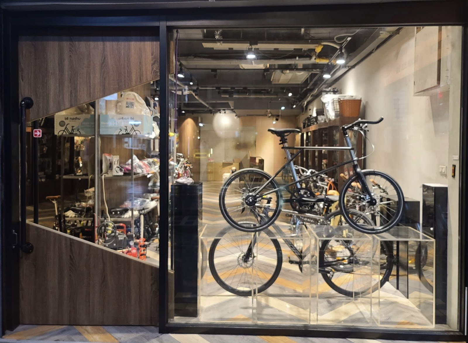 77號單車站店面櫥窗，亮著燈的店內擺著小徑車與公路車